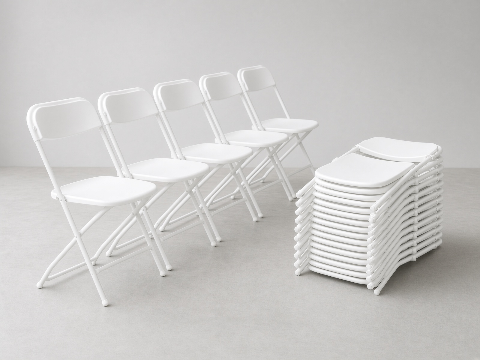 All-white folding chairs with white seats and white frames, some open and some stacked.